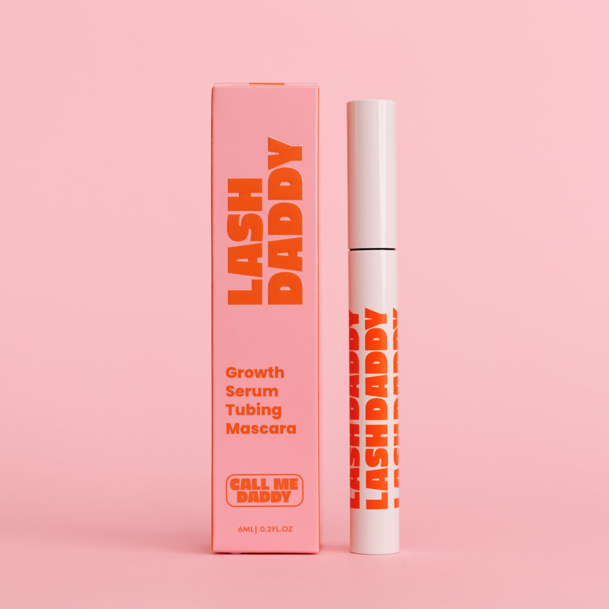 A mascara product with its packaging, the brand name is 'Lash Daddy' written in orange on a pink background.